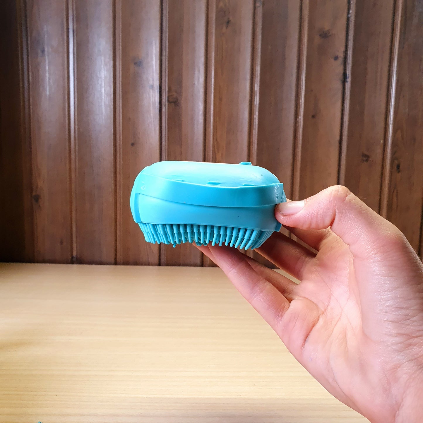Blue silicone bath body brush featuring a built-in soap dispenser for convenient showering. #3353