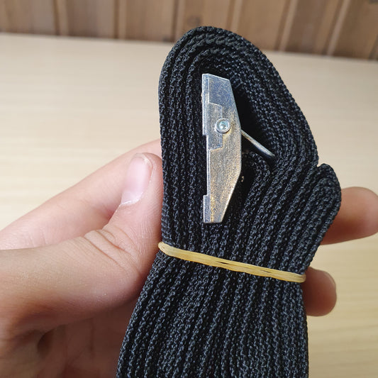 Black polypropylene cargo strap with a metal cam buckle for tie-down applications. #6711