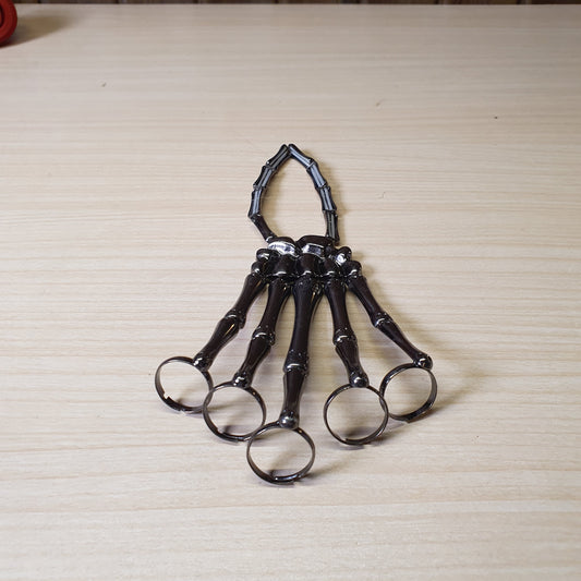 Gothic punk skeleton hand bracelet features five rings attached to a wrist chain. #4961