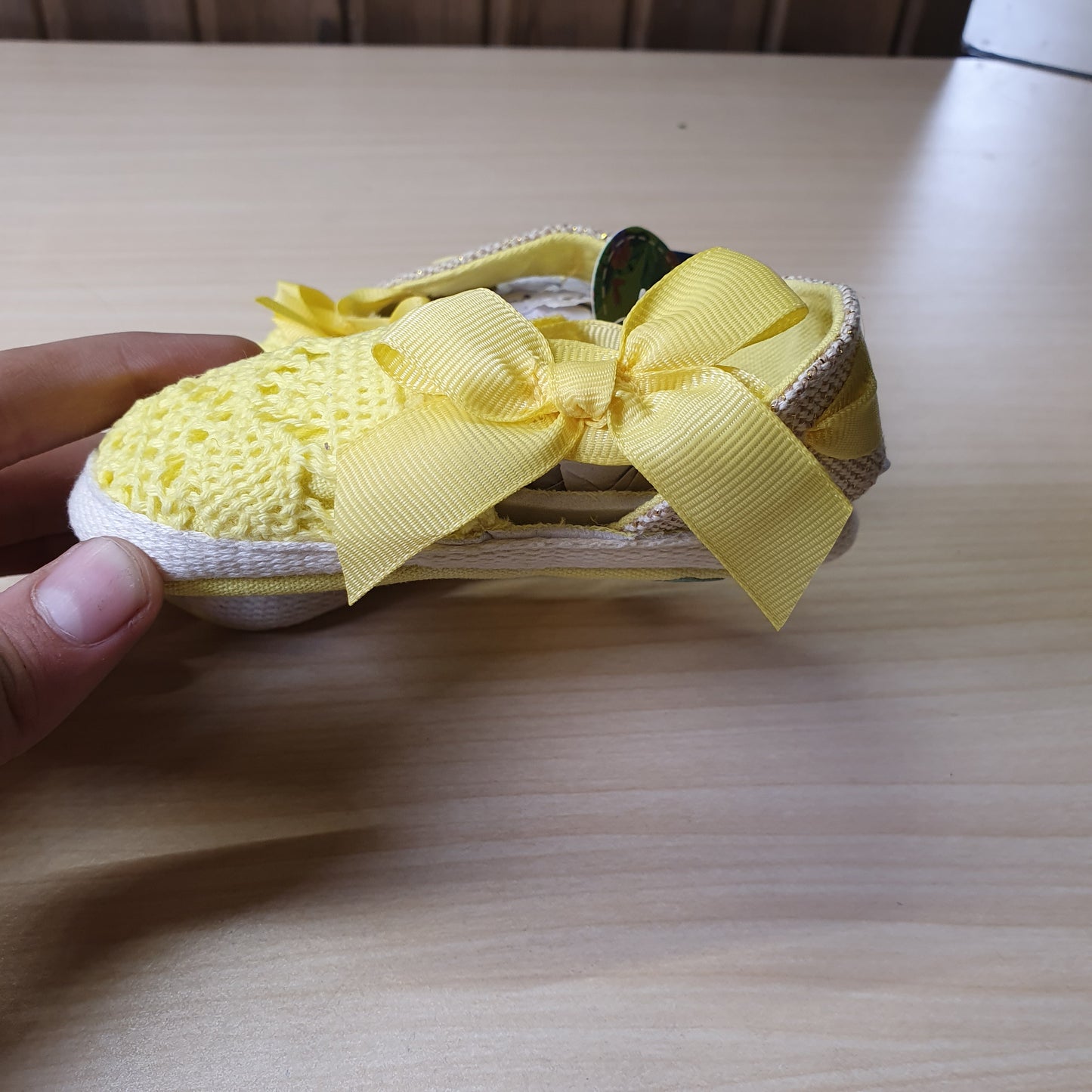 ESTAMICO baby shoes feature a vibrant yellow crocheted upper with a decorative bow on the front. #8408