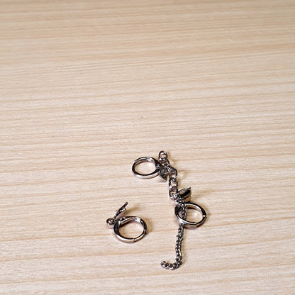 Silver-toned handcuff-style dangle earrings feature small chains and hinged hoop closures.#3492