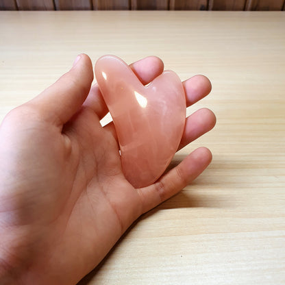 Pink, heart-shaped tool is a Gua Sha scraper, For Facial #3474