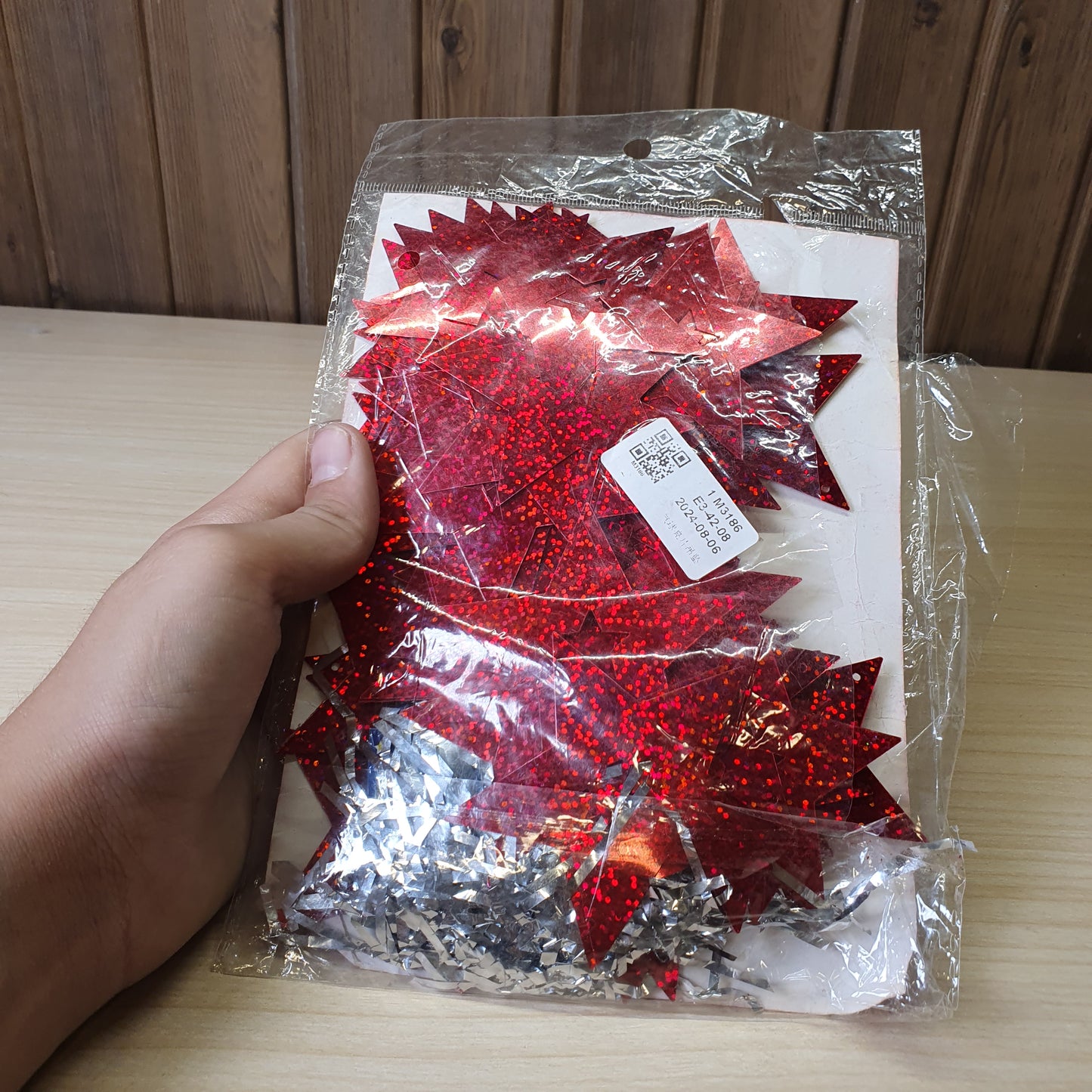 Red, star-shaped tinsel garland likely used for Christmas or party decorations.#6625