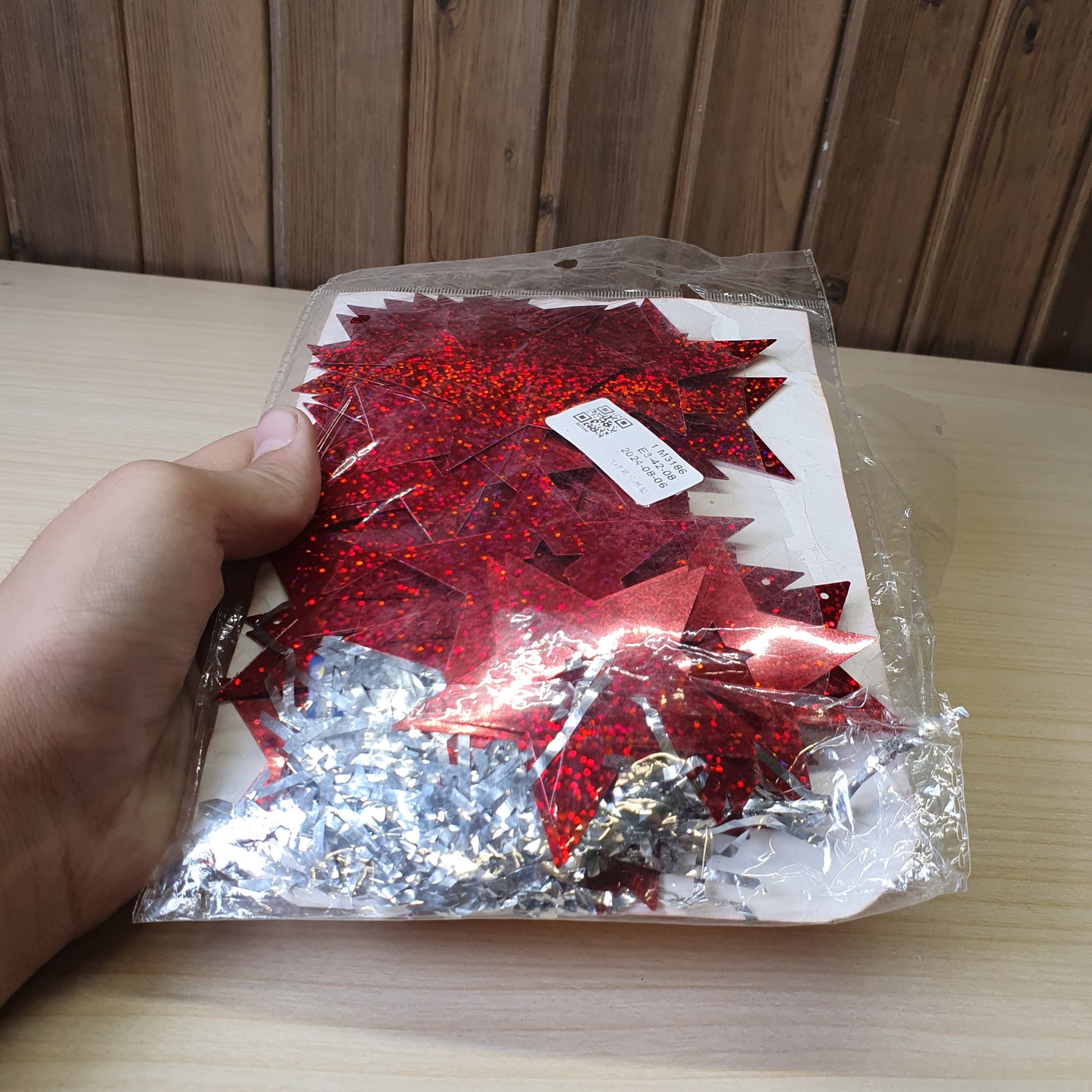 Red, star-shaped tinsel garland likely used for Christmas or party decorations.#6625