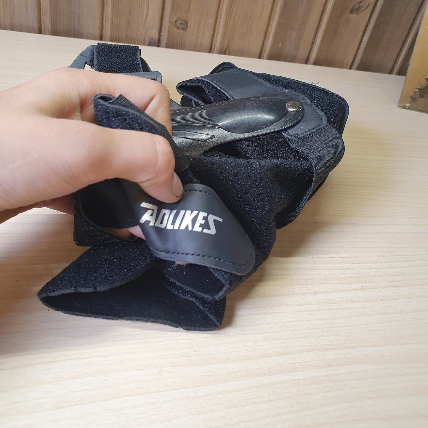 Black ankle brace with plastic side stabilizers for structural support.#6987