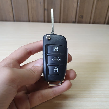 Audi flip key fob featuring a three-button layout for locking, unlocking, and trunk release. #6908