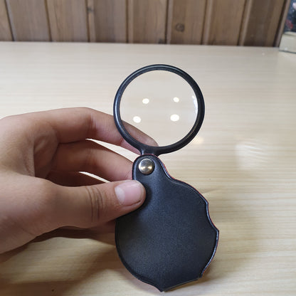 Handheld folding magnifying glass features a black protective pouch that acts as a handle #6983