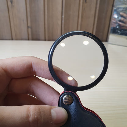 Handheld folding magnifying glass features a black protective pouch that acts as a handle #6983
