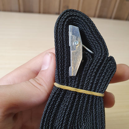 Black polypropylene cargo strap with a metal cam buckle for tie-down applications. #6711