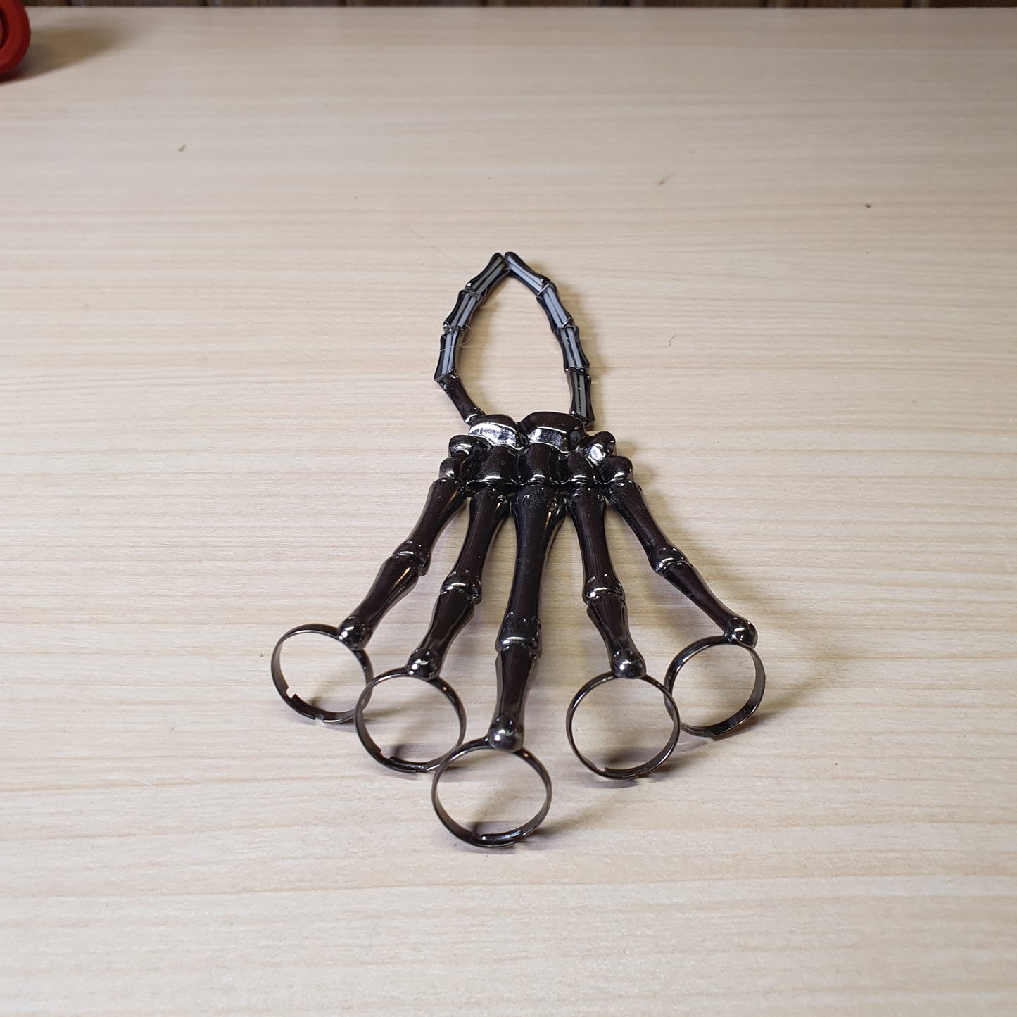 Gothic punk skeleton hand bracelet features five rings attached to a wrist chain. #4543