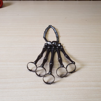 Gothic punk skeleton hand bracelet features five rings attached to a wrist chain. #4543