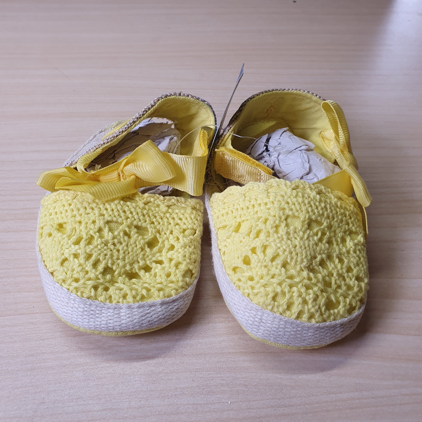 ESTAMICO baby shoes feature a vibrant yellow crocheted upper with a decorative bow on the front. #8408