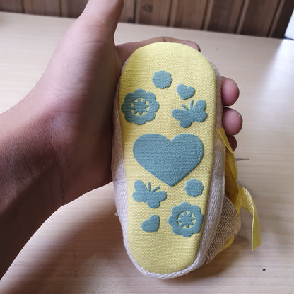 ESTAMICO baby shoes feature a vibrant yellow crocheted upper with a decorative bow on the front. #8408