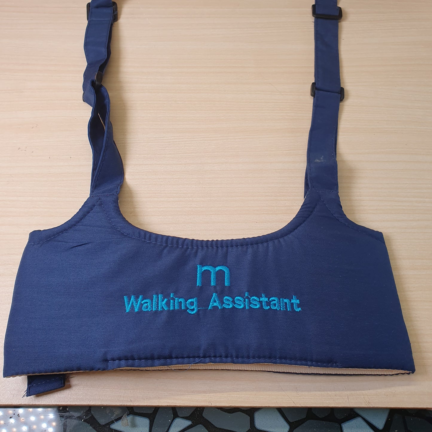 Blue baby walking assistant harness features adjustable straps and embroidered text. # 9273