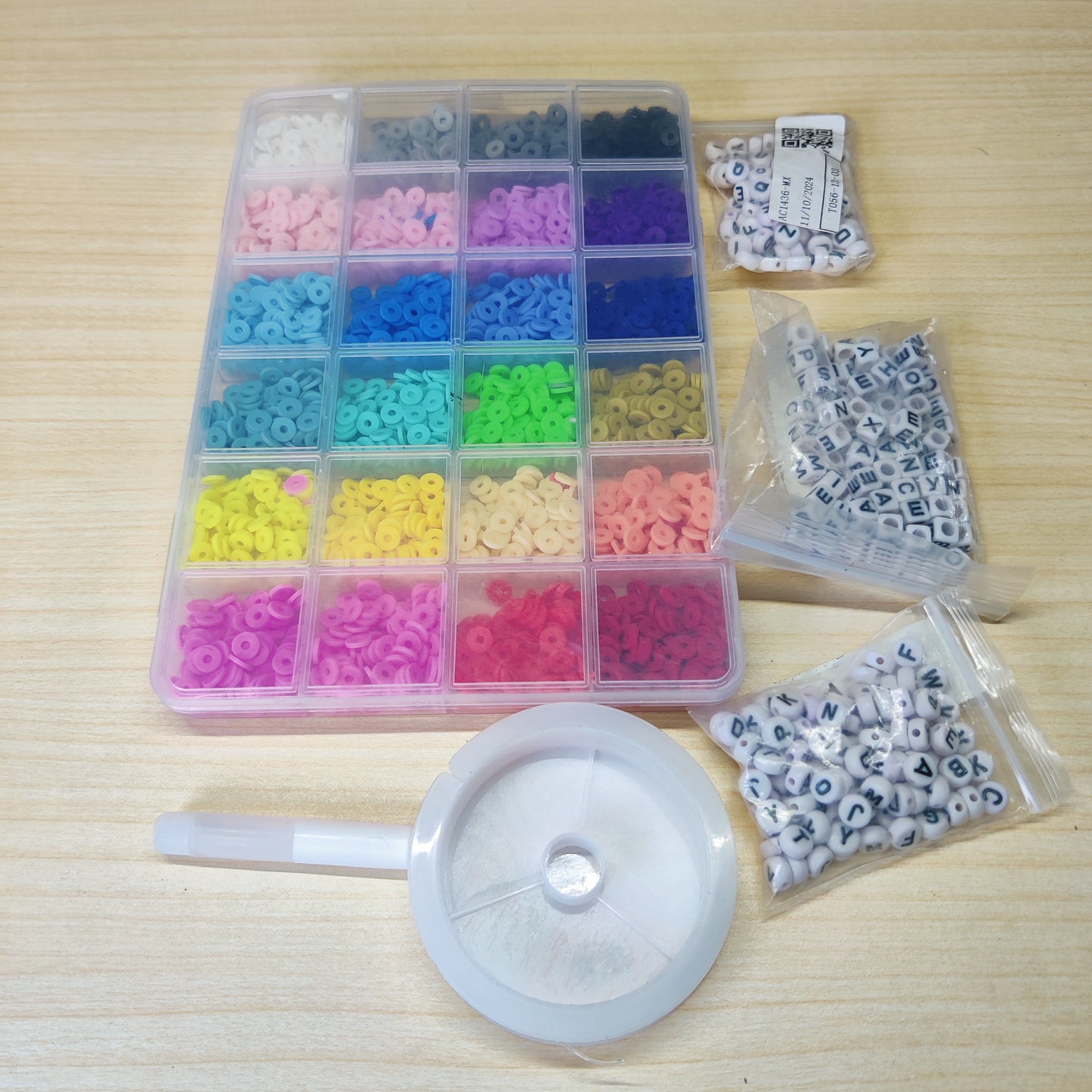 DIY jewelry making kit featuring colorful polymer clay heishi beads organized in a clear grid box. #517