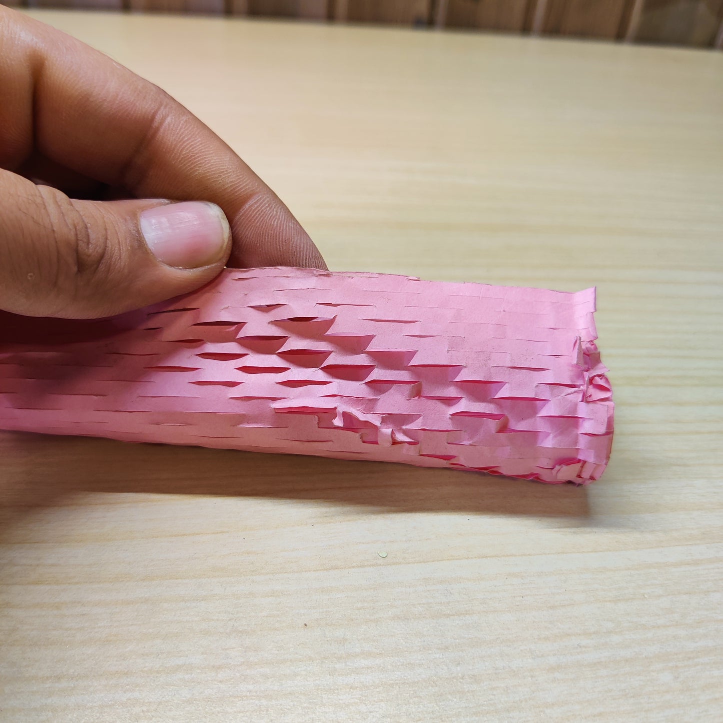 Roll of pink honeycomb packaging paper used for protective cushioning.#2609